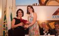 Professora Renata Piacentini Rodriguez da UNIFAL-MG entrega o prêmio à professora Virgínia Ciminelli 
